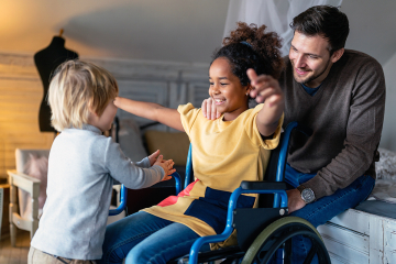 A kid in a wheel chair about to hug another child