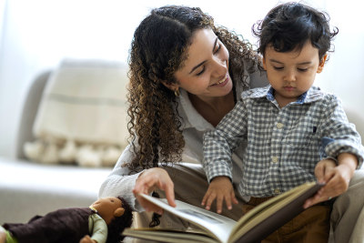 A woman reading a book with a toddler